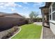 Well-maintained backyard with artificial turf, lush landscaping, and patio offers a beautiful outdoor living space at 4683 N 206Th Ln, Buckeye, AZ 85396