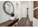 Stylish foyer features wood floors, a decorative mirror, and a bench with a potted plant at 4683 N 206Th Ln, Buckeye, AZ 85396