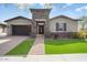 Charming single-story home featuring a stone accented entrance, manicured lawn and attached two car garage at 4683 N 206Th Ln, Buckeye, AZ 85396