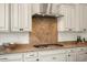 Close-up of a kitchen with a stainless steel range hood and granite backsplash at 4683 N 206Th Ln, Buckeye, AZ 85396