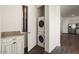 Convenient laundry area with a stacked washer and dryer, granite counters, and custom cabinets offers ease and functionality at 4683 N 206Th Ln, Buckeye, AZ 85396