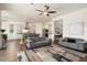 Open-concept living area with a view of the kitchen, featuring hardwood floors and stylish furniture at 4683 N 206Th Ln, Buckeye, AZ 85396