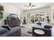 Bright living room with contemporary furnishings, wood look tile flooring, and large sliding glass doors to patio at 4683 N 206Th Ln, Buckeye, AZ 85396