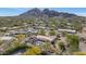 Expansive aerial view of a property with a pool, tile roof, lush greenery, and stunning mountain views in the background at 4726 E Sierra Vista Dr, Paradise Valley, AZ 85253