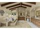 Bright bathroom featuring dual vanities, travertine tile, beamed ceilings, and a standalone tub with backyard views at 4726 E Sierra Vista Dr, Paradise Valley, AZ 85253