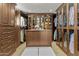 Walk-in closet with custom glass-front cabinets, drawers, a center island, and ample storage space at 4726 E Sierra Vista Dr, Paradise Valley, AZ 85253