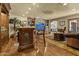 Open living area featuring custom ceiling work, a full bar with seating, and beautiful wood flooring at 4726 E Sierra Vista Dr, Paradise Valley, AZ 85253