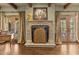 Elegant living room featuring a stone fireplace, wood floors, and double doors leading to the outside at 4726 E Sierra Vista Dr, Paradise Valley, AZ 85253