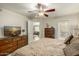 Bright bedroom with ceiling fan, dresser with TV, and access to another room in the house at 4850 E Desert Cove Ave # 227, Scottsdale, AZ 85254