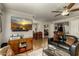 Open concept living room showcasing a large TV, wood floors, and access to dining area at 4850 E Desert Cove Ave # 227, Scottsdale, AZ 85254