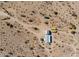 Aerial view of a property showing desert landscape, buildings, and dirt roads at 53040 W Whirly Bird Rd, Maricopa, AZ 85139