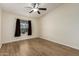 Bedroom features wood-look flooring, neutral walls, and a window for natural light and ceiling fan at 53040 W Whirly Bird Rd, Maricopa, AZ 85139