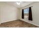 Bedroom features wood-look flooring, neutral walls, and a window for natural light at 53040 W Whirly Bird Rd, Maricopa, AZ 85139