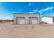 A garage on a desert lot featuring two white garage doors and a blue sky background at 53040 W Whirly Bird Rd, Maricopa, AZ 85139