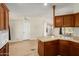 Kitchen featuring wood cabinets, an island, and an open design to the living area at 53040 W Whirly Bird Rd, Maricopa, AZ 85139