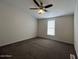 Cozy bedroom featuring plush carpeting, a ceiling fan, and a bright window at 538 S 98Th St, Mesa, AZ 85208