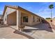 Covered back patio featuring neutral stucco exterior, concrete, and lush desert landscaping at this home at 6121 S Ruby Dr, Chandler, AZ 85249