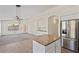 Bright kitchen featuring an island, stainless steel fridge, ample cabinet space, and tile flooring at 6121 S Ruby Dr, Chandler, AZ 85249