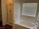 Bright bathroom featuring a walk-in shower and a separate soaking tub beneath a window with blinds at 6531 W Hess S St, Phoenix, AZ 85043