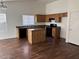 Open kitchen with wood cabinets, black appliances, a center island, and wood-look flooring at 6531 W Hess S St, Phoenix, AZ 85043