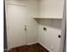 Laundry room with a white door, wood floor, and a shelf at 6531 W Hess S St, Phoenix, AZ 85043
