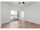 Light-filled bedroom featuring wood floors, a ceiling fan, and sliding glass doors to the balcony at 7101 W Beardsley Rd # 722, Glendale, AZ 85308