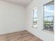 A vacant bedroom with two windows and wood-look floors at 7101 W Beardsley Rd # 722, Glendale, AZ 85308