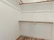Walk-in closet with wood-style floor and white walls with wood rods and shelving at 7101 W Beardsley Rd # 722, Glendale, AZ 85308