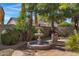 Close-up view of the backyard fountain, surrounded by lush greenery and a tiled patio area at 721 W Cherrywood Dr, Chandler, AZ 85248