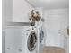 Well-equipped laundry room with modern washer, dryer, and ample cabinet storage at 721 W Cherrywood Dr, Chandler, AZ 85248
