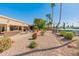 Backyard featuring desert landscaping, covered patio, and multiple outdoor seating areas overlooking the water at 9945 W Cameo Dr, Sun City, AZ 85351