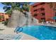 Scenic waterfall feature flowing into the pool alongside blue railings, providing a tranquil ambiance at 12222 N Paradise Village S Pkwy # 224, Phoenix, AZ 85032