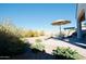 Landscaped backyard featuring a stone patio with umbrella-covered table and desert landscaping at 12330 E Crystal Frst, Gold Canyon, AZ 85118