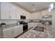 Well-lit kitchen with white cabinets, stainless steel appliances, and granite countertops on a kitchen island at 12330 E Crystal Frst, Gold Canyon, AZ 85118