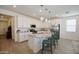 Modern kitchen with white cabinets, stainless steel appliances, island with stools, and stylish pendant lighting at 12330 E Crystal Frst, Gold Canyon, AZ 85118