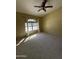 Bedroom with neutral paint, carpet, a ceiling fan, and a large window allowing plenty of sunlight at 1302 E Tierra Buena Ln, Phoenix, AZ 85022