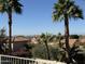 Neighborhood rooftops peek through the palm trees with distant mountain views at 1302 E Tierra Buena Ln, Phoenix, AZ 85022