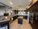 Modern kitchen with granite countertops, stainless steel appliances, dark cabinetry, and an island at 1302 E Tierra Buena Ln, Phoenix, AZ 85022