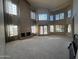 Spacious living room featuring large windows, high ceilings, neutral colors, and a fireplace at 1302 E Tierra Buena Ln, Phoenix, AZ 85022