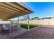 Covered patio with a table and chairs overlooking a manicured backyard with artificial turf at 1322 S Oracle --, Mesa, AZ 85204
