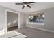 This bedroom features neutral carpet, a ceiling fan, a large window, and base trim molding at 1322 S Oracle --, Mesa, AZ 85204