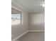 This bedroom features neutral carpet, a ceiling fan, a large window, and base trim molding at 1322 S Oracle --, Mesa, AZ 85204