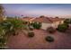 Spacious backyard with desert landscaping, mature trees, and a covered patio at 13434 W El Sueno Ct, Sun City West, AZ 85375