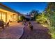 Inviting backyard with brick paver patio, desert landscaping, and soft landscape lighting at 13434 W El Sueno Ct, Sun City West, AZ 85375