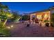 Picturesque backyard featuring a brick paver patio, desert plants, and landscape lighting at 13434 W El Sueno Ct, Sun City West, AZ 85375