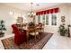 Dining room featuring a chandelier, red accented chairs, and large windows at 13434 W El Sueno Ct, Sun City West, AZ 85375