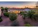 Charming single-story home with a red tile roof, desert landscaping, and a beautiful sunset at 13434 W El Sueno Ct, Sun City West, AZ 85375