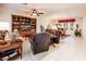 A spacious living room area featuring comfortable seating, a built-in entertainment center, and tile floors at 13434 W El Sueno Ct, Sun City West, AZ 85375