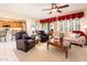 Inviting living room with plush seating, ceiling fan, and view into kitchen at 13434 W El Sueno Ct, Sun City West, AZ 85375