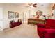 This main bedroom features carpeted floors, a wood bed frame, and an accompanying red armchair at 13434 W El Sueno Ct, Sun City West, AZ 85375